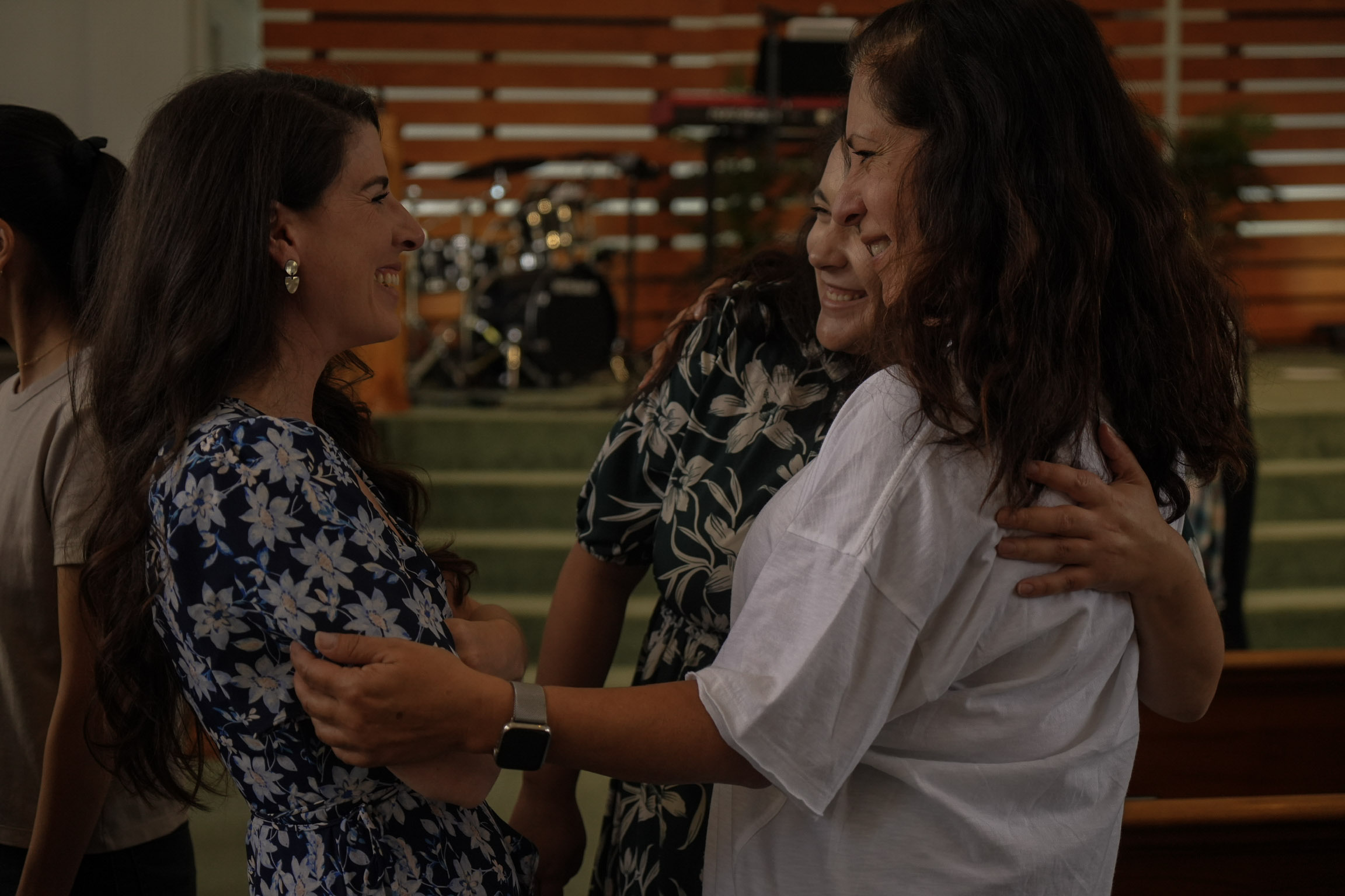 Two women hugging and laughing after a service